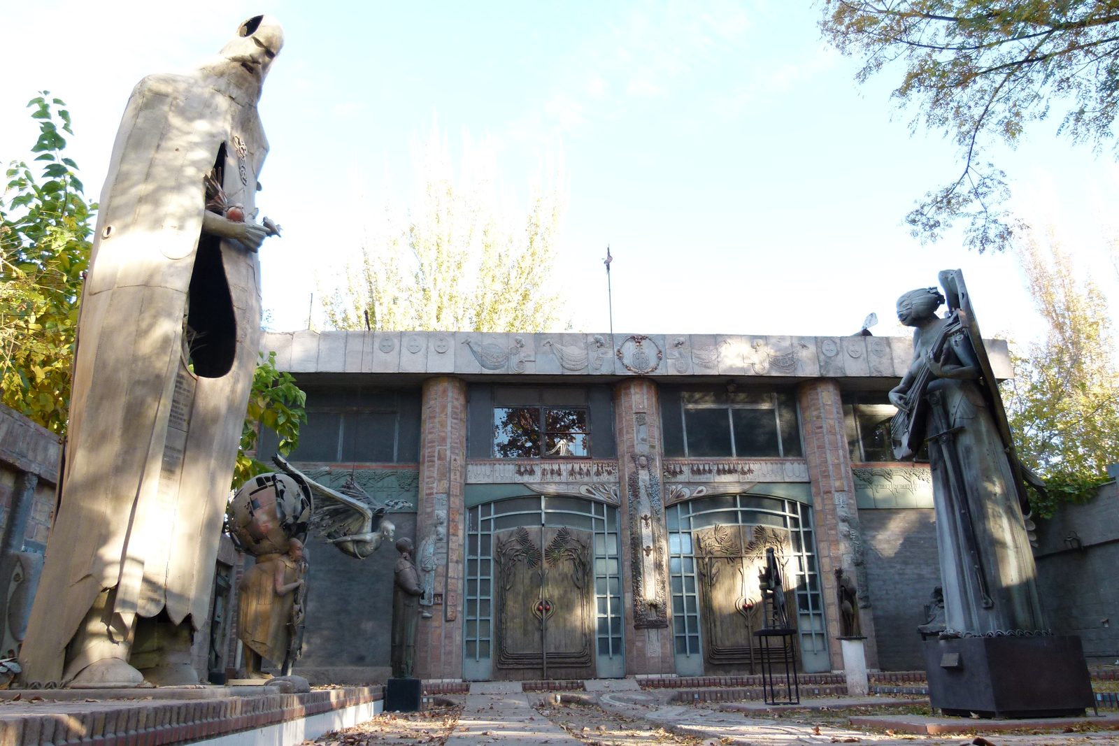 Fachada de la Casa del Escultor con dos esculturas colosales de hierro flanqueando la entrada