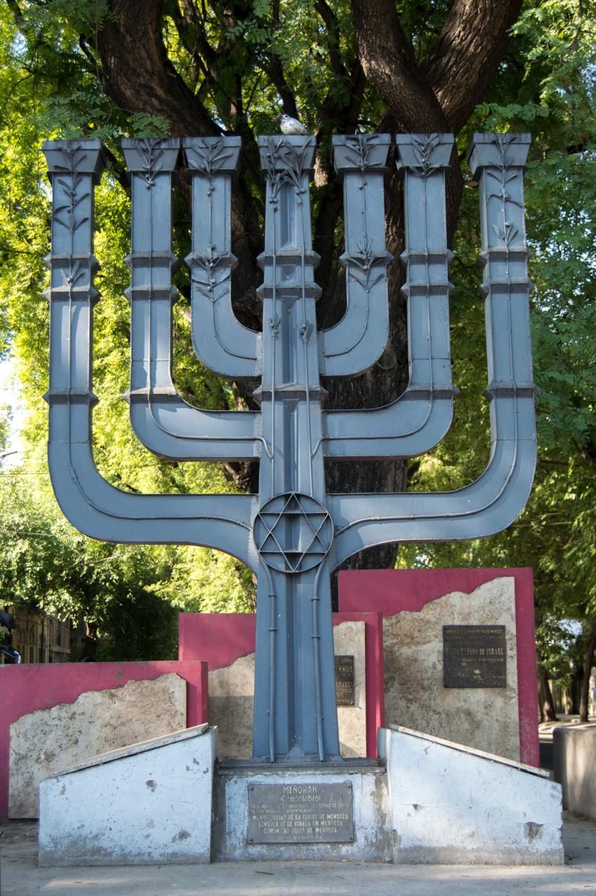 Menorah, vista frontal del candelabro de hierro bajo los árboles