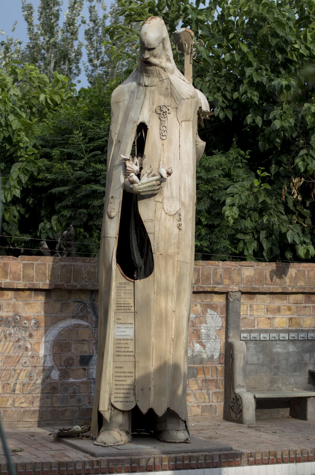 Patio de los Colosos, figura encapuchada con pájaros en brazos
