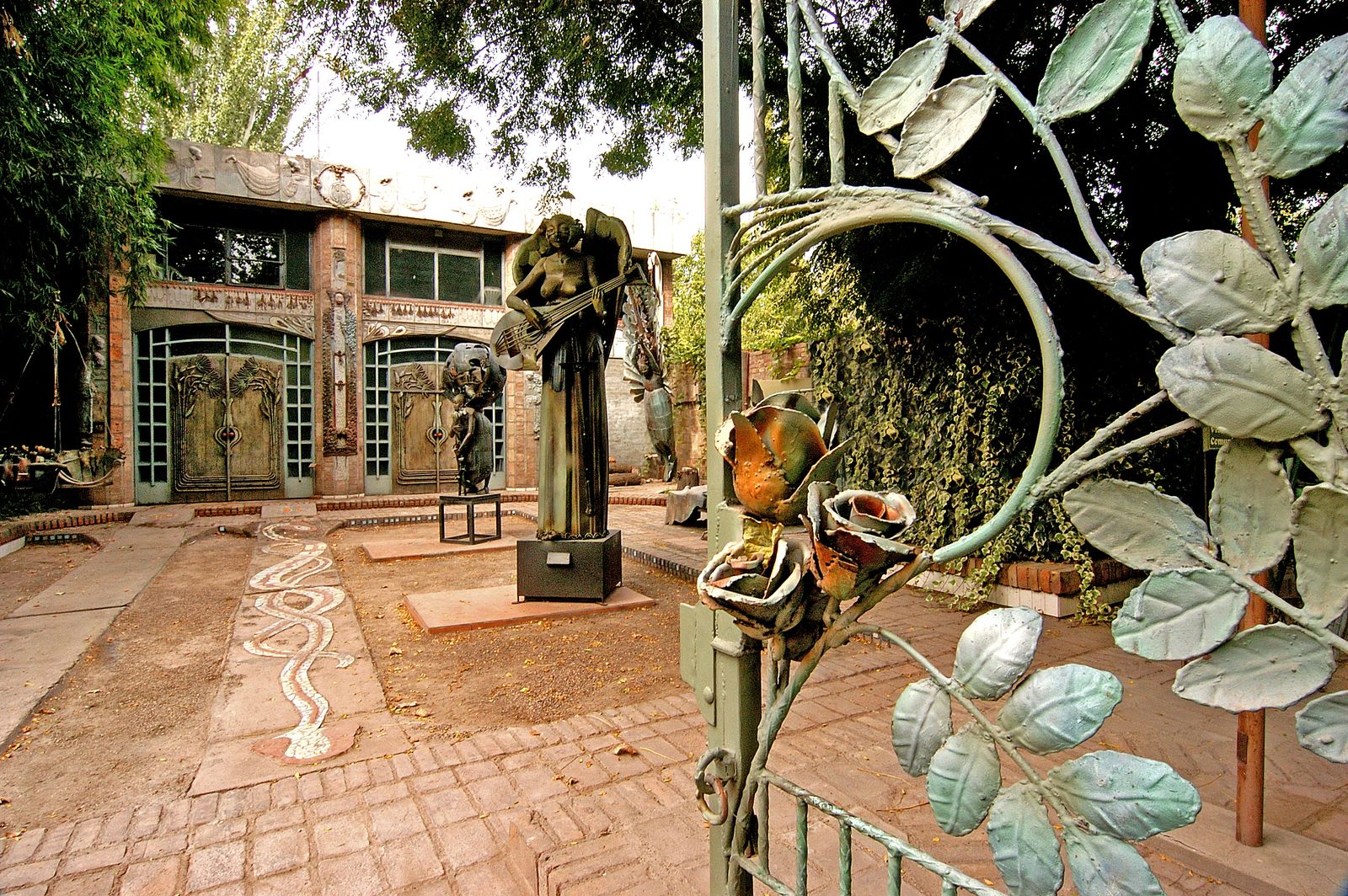 Portón de hierro forjado, vista completa con el patio y las esculturas al fondo